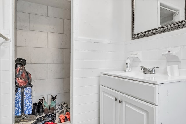 bathroom with vanity and tile walls