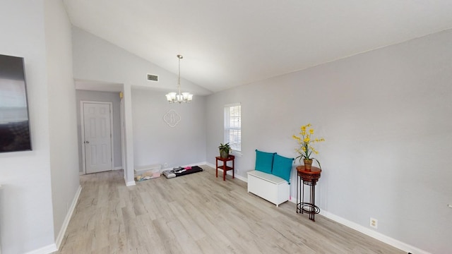 sitting room with vaulted ceiling, a chandelier, and light hardwood / wood-style floors