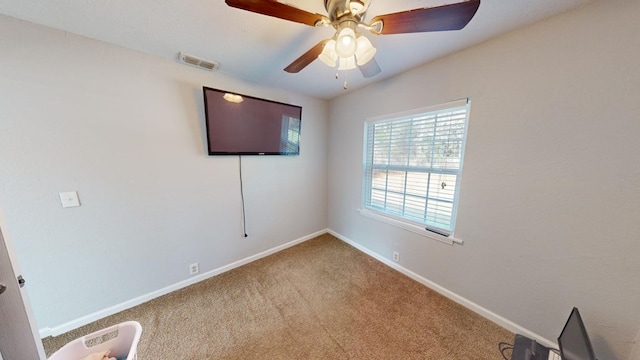 unfurnished room featuring ceiling fan and carpet