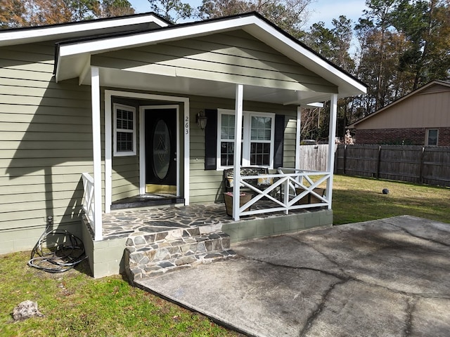 property entrance featuring a yard and covered porch