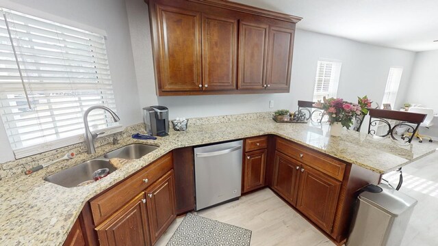 kitchen with light stone counters, sink, stainless steel dishwasher, and kitchen peninsula