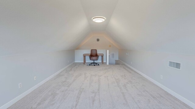 unfurnished office with vaulted ceiling and light carpet