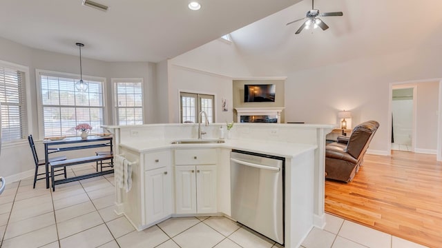 kitchen with pendant lighting, sink, stainless steel dishwasher, and a center island with sink