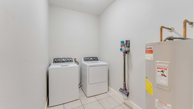 clothes washing area featuring light tile patterned floors, electric water heater, and washing machine and clothes dryer