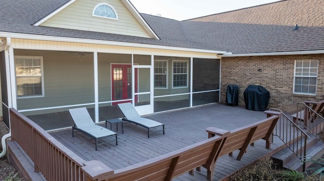 deck with a grill and a sunroom