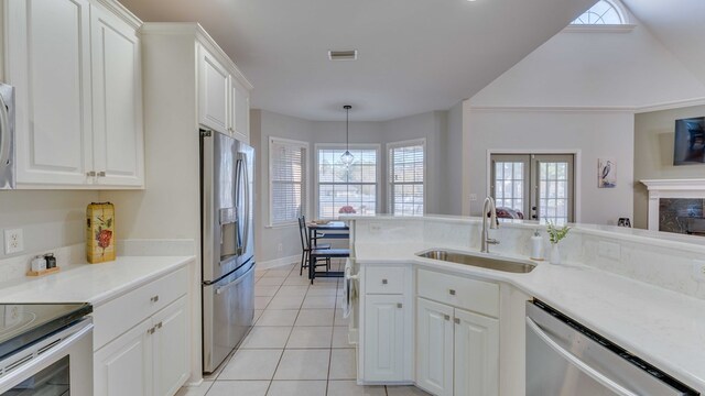 kitchen featuring light tile patterned flooring, sink, pendant lighting, stainless steel appliances, and white cabinets