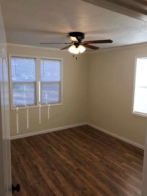 empty room with dark wood-style floors, ceiling fan, and baseboards