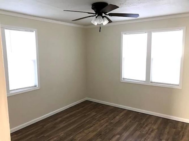 spare room with crown molding, baseboards, ceiling fan, and dark wood-style flooring