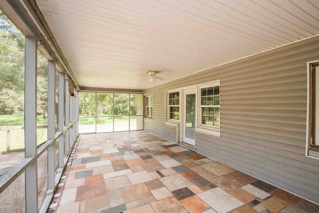 unfurnished sunroom featuring a ceiling fan