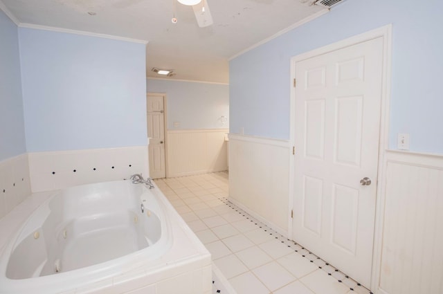 bathroom with a wainscoted wall, ornamental molding, a jetted tub, and tile patterned floors