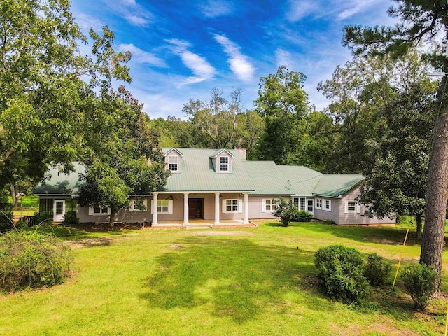 back of house with a chimney, a patio, metal roof, and a yard