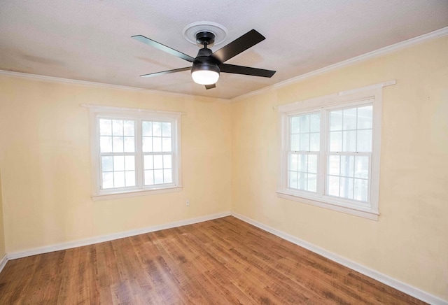 spare room with a ceiling fan, crown molding, and baseboards