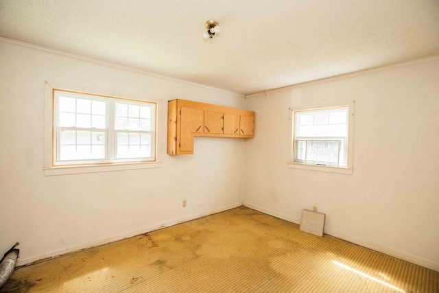 unfurnished room featuring ornamental molding, baseboards, and light carpet