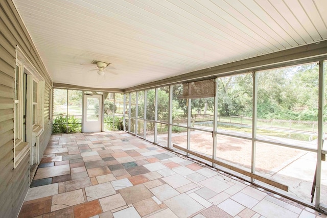 unfurnished sunroom featuring a ceiling fan