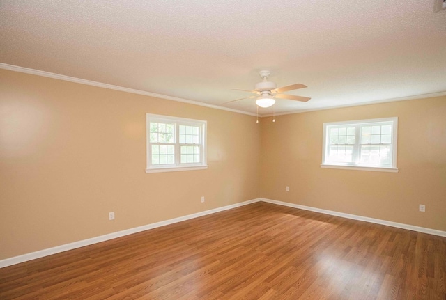 unfurnished room featuring plenty of natural light, baseboards, wood finished floors, and ceiling fan