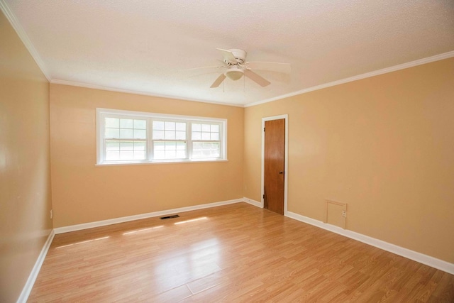 empty room with visible vents, baseboards, ornamental molding, a ceiling fan, and light wood-type flooring