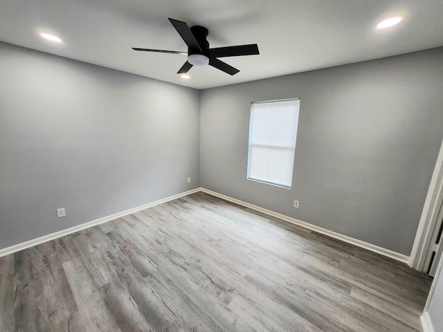 empty room featuring a ceiling fan, recessed lighting, baseboards, and wood finished floors