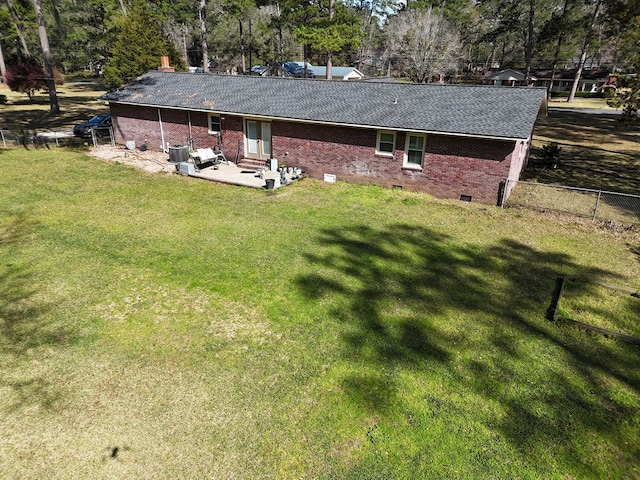 back of property with entry steps, a lawn, fence, a patio area, and brick siding