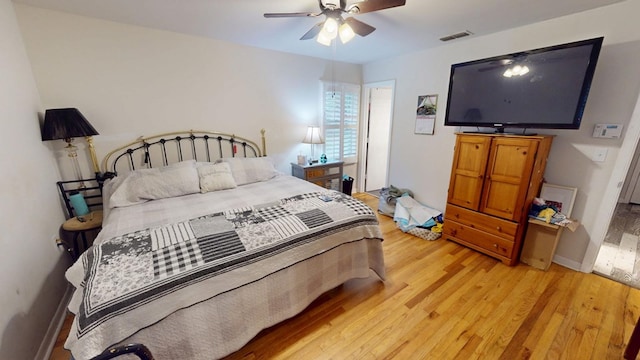 bedroom featuring light wood-style floors, ceiling fan, visible vents, and baseboards