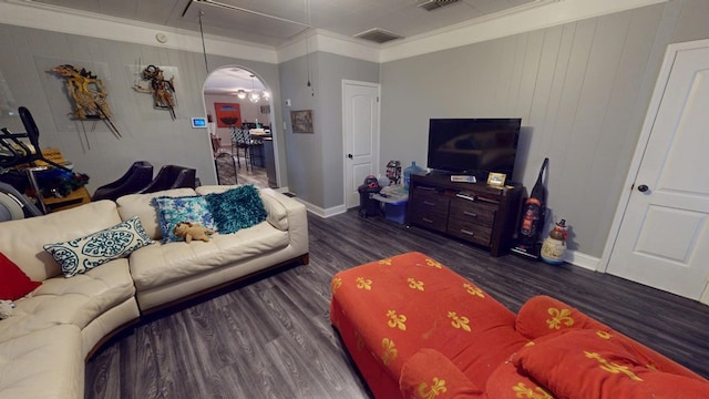 living room featuring dark wood-style floors, arched walkways, visible vents, and crown molding