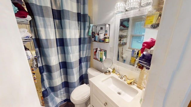 bathroom featuring curtained shower, vanity, and toilet