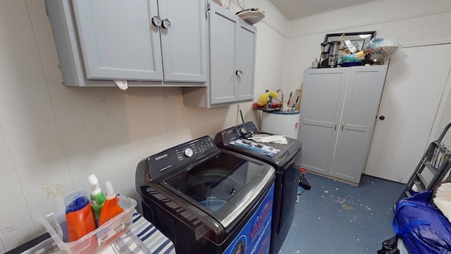 laundry room with gas water heater, washing machine and dryer, and cabinet space