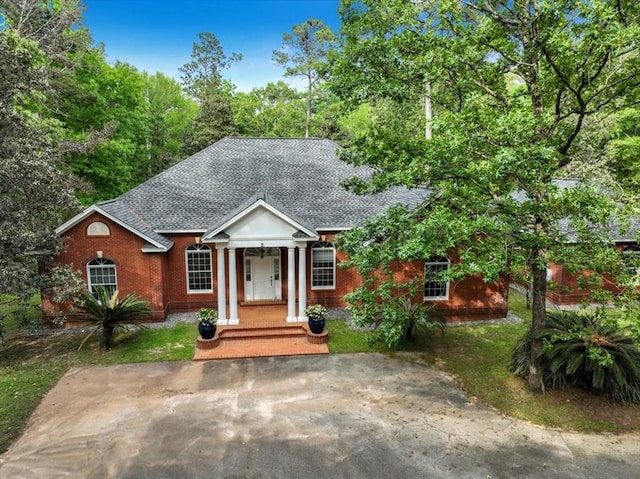 view of front of house with brick siding and a shingled roof