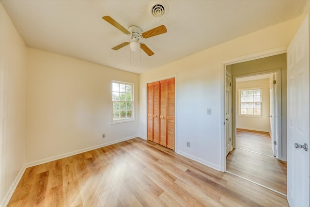 unfurnished bedroom featuring ceiling fan, light hardwood / wood-style floors, and a closet