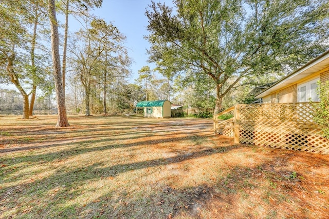 view of yard featuring a deck and a storage unit