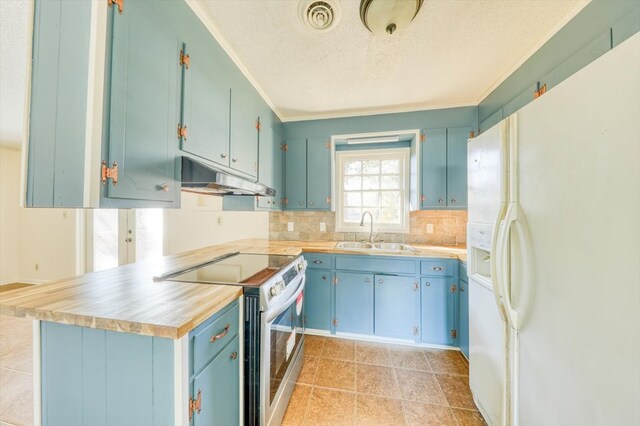 kitchen featuring sink, white fridge with ice dispenser, blue cabinets, stainless steel range with electric cooktop, and kitchen peninsula