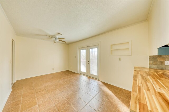 unfurnished room with ceiling fan, ornamental molding, french doors, and a textured ceiling