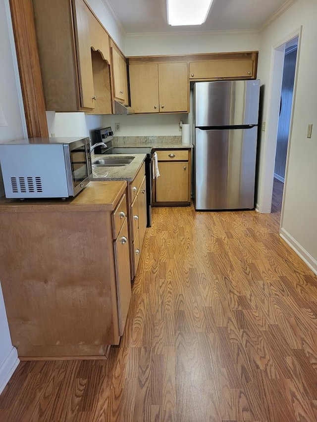 208 Pine St, Quitman, GA 31643 - kitchen with stainless steel appliances, crown molding, baseboards, light wood-type flooring, and light countertops