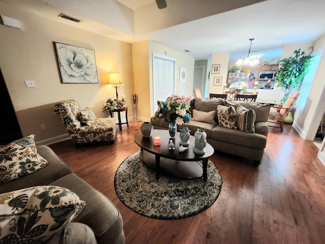 living area with a chandelier, wood finished floors, and baseboards