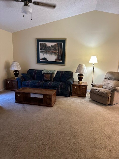 living room with ceiling fan, lofted ceiling, and carpet