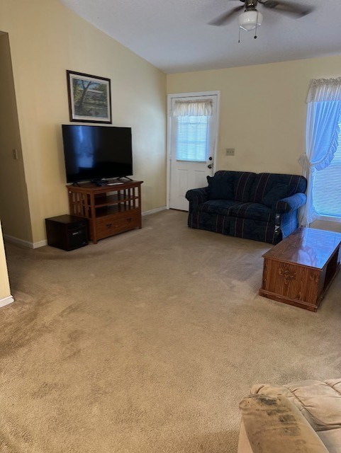 carpeted living room featuring vaulted ceiling and ceiling fan