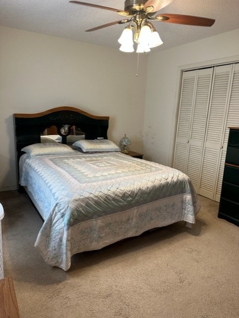 carpeted bedroom with ceiling fan, a textured ceiling, and a closet