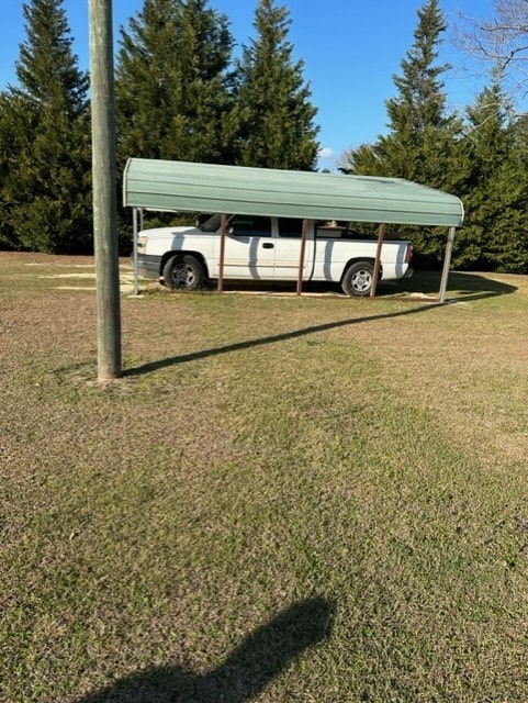 view of car parking with a carport and a yard