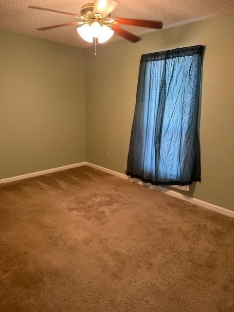 spare room featuring ceiling fan, carpet floors, and a textured ceiling