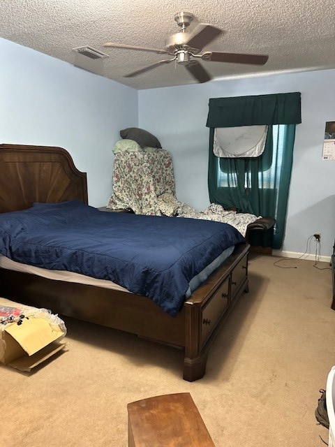 bedroom with light carpet, a textured ceiling, and ceiling fan