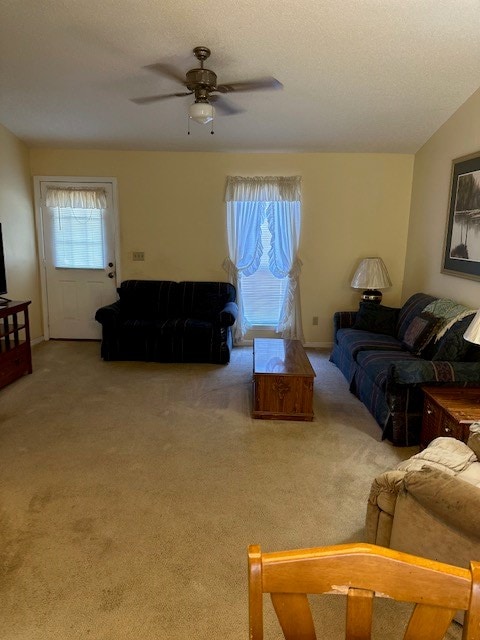 living room featuring carpet, a textured ceiling, and ceiling fan