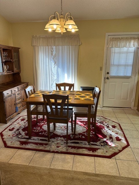 dining room featuring an inviting chandelier, light tile patterned floors, and a textured ceiling