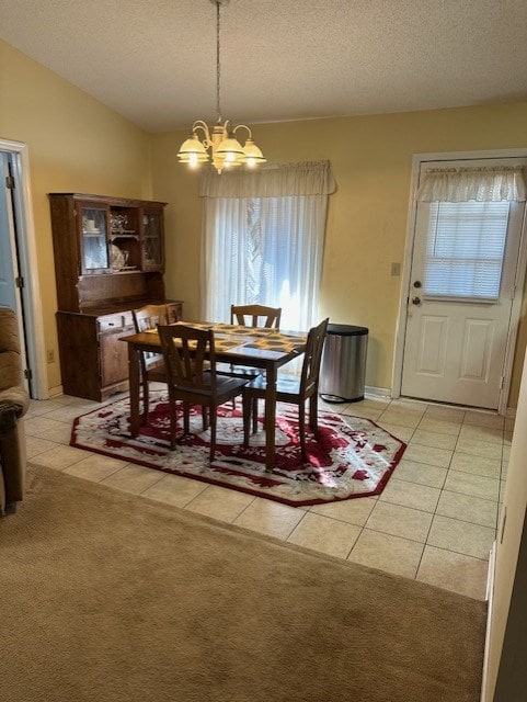 dining area with vaulted ceiling, light tile patterned floors, a notable chandelier, and a textured ceiling