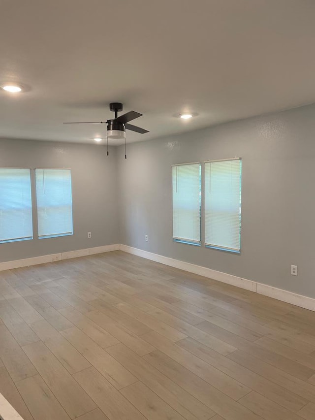 empty room with a ceiling fan, recessed lighting, light wood-style flooring, and baseboards