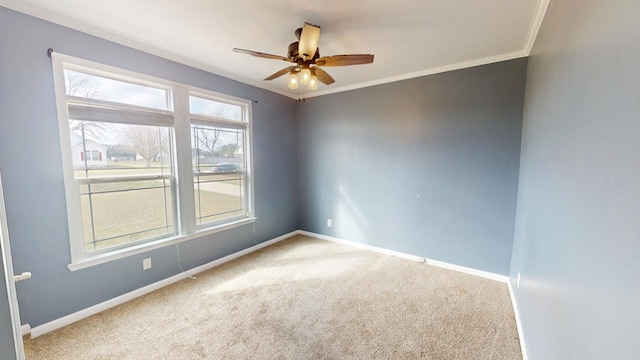 spare room featuring carpet floors, ornamental molding, and ceiling fan