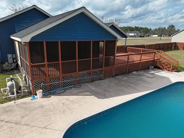 rear view of house with central AC, a sunroom, a fenced in pool, and a patio