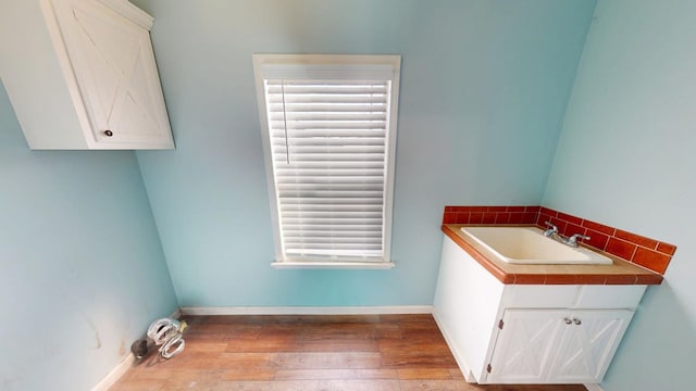 clothes washing area featuring sink and light wood-type flooring