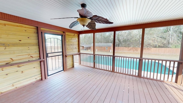 unfurnished sunroom featuring ceiling fan