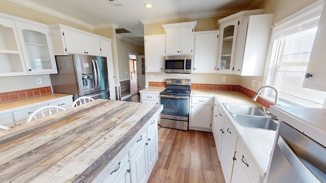 kitchen featuring sink, stainless steel appliances, white cabinets, and light wood-type flooring