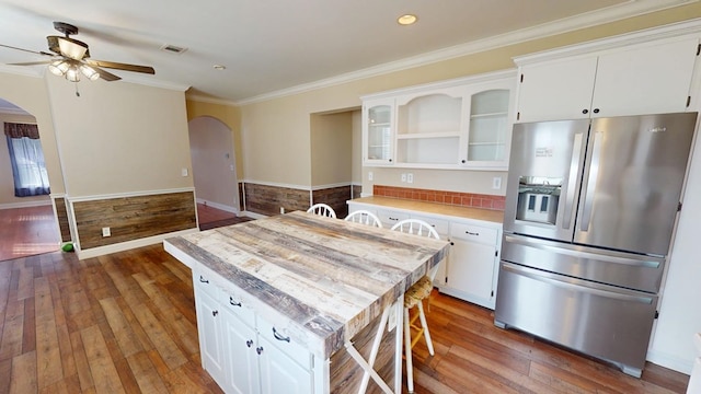 kitchen featuring stainless steel refrigerator with ice dispenser, dark hardwood / wood-style floors, a center island, and white cabinets