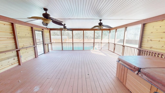 unfurnished sunroom with ceiling fan